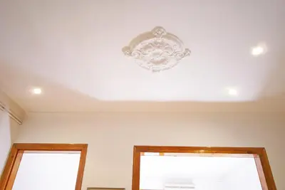a white ceiling with a chandelier above two windows at Flateli Aribau in Barcelona