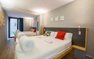 a room with two beds and a living room at Yeah Barcelona Hostel in Barcelona