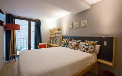 a bedroom with a large bed with pillows at Yeah Barcelona Hostel in Barcelona