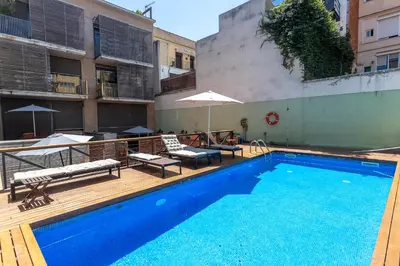 a pool with chairs and umbrellas next to a building at My Space Barcelona Gracia Pool Terrace in Barcelona
