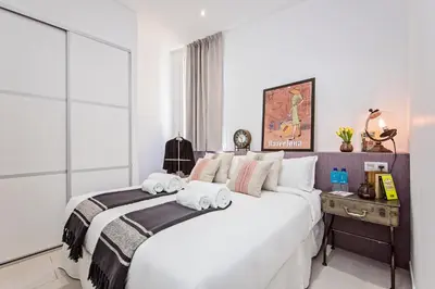 a bedroom with a large white bed with towels on it at Sweett - Sants in Barcelona