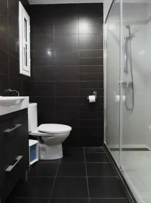 a bathroom with a toilet and a glass shower at Joanic Apartment Escorial in Barcelona