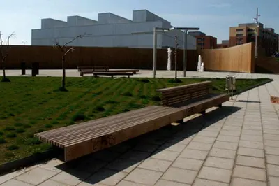 a bench in a park with a building in the background at Maria House. in Viladecáns