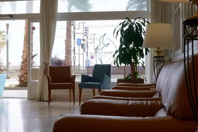 a lobby with couches and chairs and a large window at Hotel Miramar Badalona in Badalona
