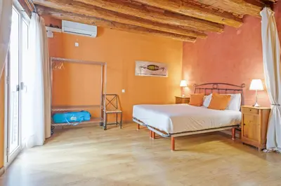 a bedroom with a bed and an orange wall at Alcam Flassaders in Barcelona