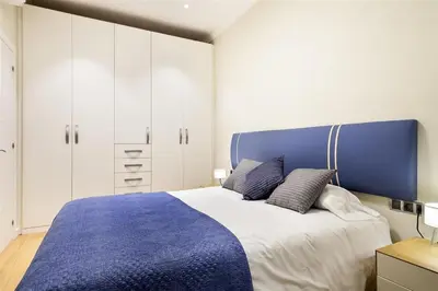 a bedroom with a large bed with a blue headboard at Alcam Trafalgar in Barcelona