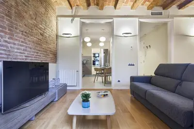 a living room with a couch and a tv at Alcam Trafalgar in Barcelona