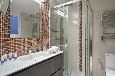 a bathroom with a sink and a glass shower at Alcam Trafalgar in Barcelona