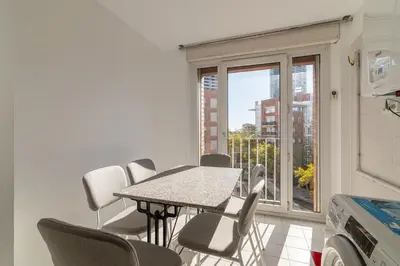 a table and chairs in a room with a window at Stay U-nique Apartments Salvador Espriu in Barcelona