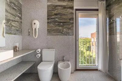 a bathroom with a toilet and a window at Stay U-nique Apartments Salvador Espriu in Barcelona