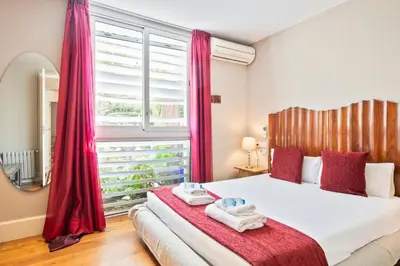 a bedroom with a large bed with red curtains at Alcam Olimpic in Barcelona