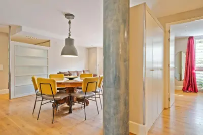 a dining room and living room with a table and chairs at Alcam Olimpic in Barcelona