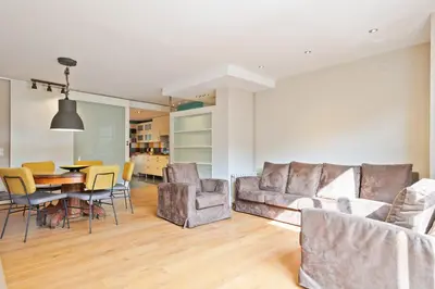 a living room with a couch and a table and chairs at Alcam Olimpic in Barcelona