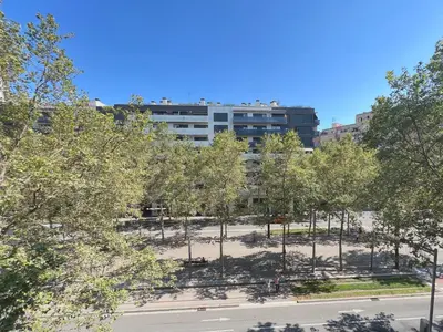 a park with trees in front of a building at Stay U-nique Apartments Venecuela in Barcelona
