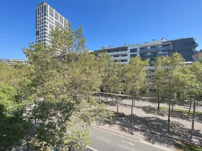 a city street with trees and a tall building at Stay U-nique Apartments Venecuela in Barcelona