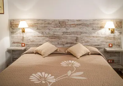 a bedroom with a bed with two lamps on it at Hotel Can Missé in Collbató