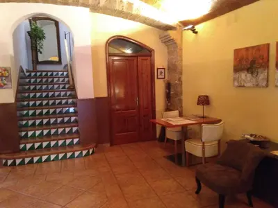 a hallway with a staircase and a table and a door at Hotel Can Missé in Collbató