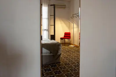 a bedroom with a bed and a red chair at MH Apartments Tetuan in Barcelona