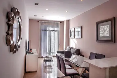 a living room with a glass table and chairs at Aparthotel Rambla108 in Barcelona
