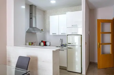 a kitchen with white cabinets and a refrigerator at Aparthotel Rambla108 in Barcelona