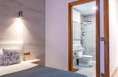 a bathroom with a bed and a toilet and a mirror at Aparthotel Rambla108 in Barcelona