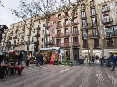 a group of people walking on a city street with buildings at Aparthotel Rambla108 in Barcelona