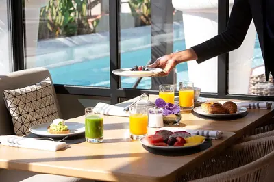 a table with a person holding a plate of food at Monument Hotel in Barcelona