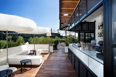 an outdoor patio with white couches and a bar at Monument Hotel in Barcelona