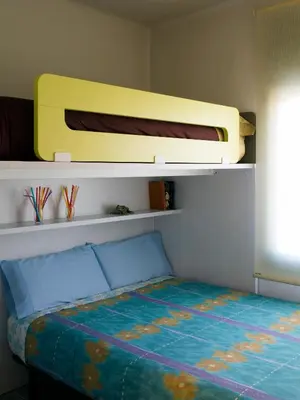 a bed in a bedroom with a yellow bunk bed at Cal Negri in Vilafranca del Penedès