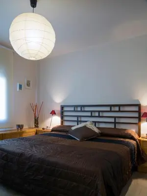 a bedroom with a large bed and a large lamp at Cal Negri in Vilafranca del Penedès