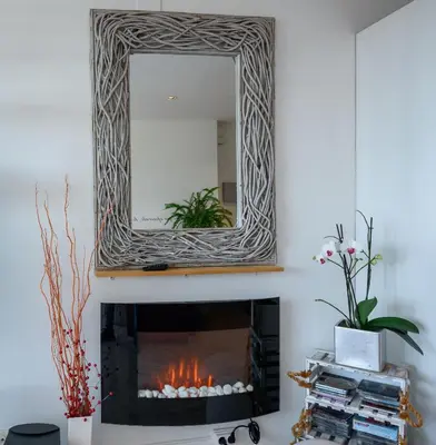 a fireplace with a mirror above it in a living room at Apartamento Reisol in Castelldefels