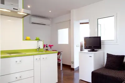 a kitchen with white cabinets and a tv on a counter at Best deal PENTHOUSE! in Barcelona