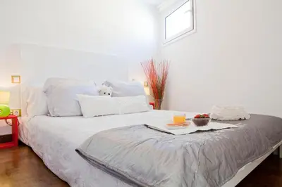 a white bed with a dog sitting on top of it at Best deal PENTHOUSE! in Barcelona