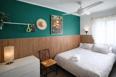 a bedroom with a bed and a green wall at Bianca Seaview & Beach Apartment in Montgat