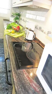 a kitchen counter with a stove and a sink at Bianca Seaview & Beach Apartment in Montgat