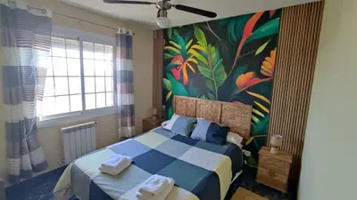 a bedroom with a bed with a painting on the wall at Bianca Seaview & Beach Apartment in Montgat