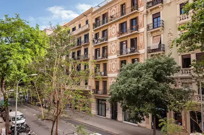 an apartment building on a street with trees at Sweett - Rosemarine in Barcelona