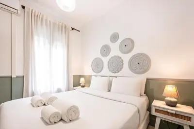 a white bedroom with two beds with towels on them at Sweett - Rosemarine in Barcelona