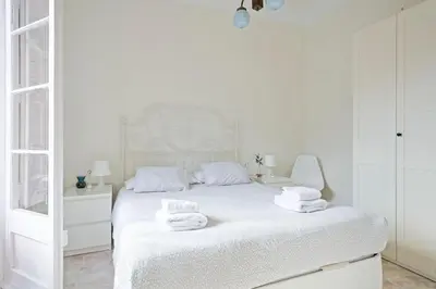 a white bedroom with a bed with towels on it at Apartmento Industria in Barcelona