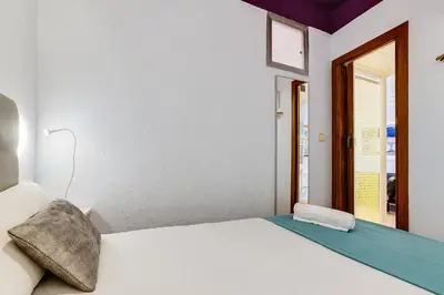 a white bed in a room with a window at Deep Purple in Barcelona