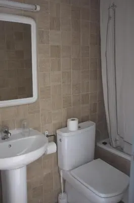 a bathroom with a toilet and a sink and a mirror at Hostal Europa in Barcelona