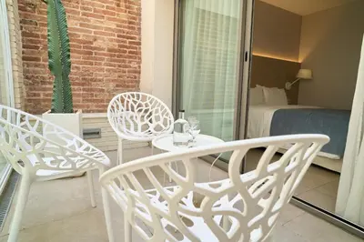 a white table and chairs on a balcony with a bed at Hotel Omnium in Barcelona