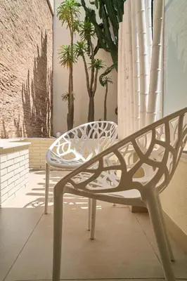 a white bench sitting in a room with palm trees at Hotel Omnium in Barcelona