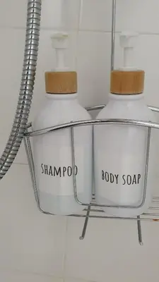 two white bottles on a shelf in a bathroom at Can Marc in Sant Esteve de Palautordera