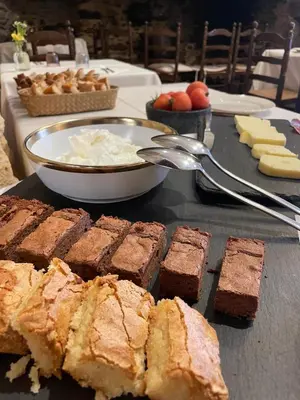 a table topped with brownies and a plate of desserts at Can Marc in Sant Esteve de Palautordera