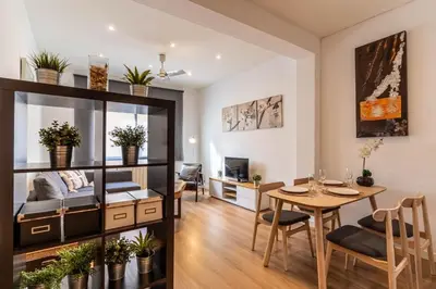 a living room and dining room with a dining table and a living room with at Lindo apartamento Vila de Gracia in Barcelona
