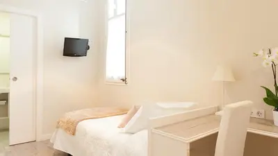 a white bedroom with a sink and a mirror at Hostal Oliva in Barcelona