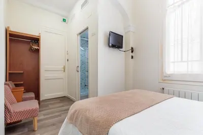 a bedroom with a bed and a tv on a wall at Hostal Oliva in Barcelona