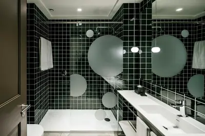 a black tiled bathroom with two sinks and mirrors at Midtown Apartments in Barcelona