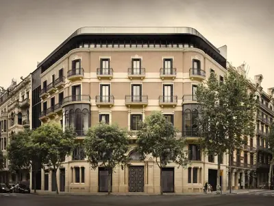 a large white building with trees in front of it at Midtown Apartments in Barcelona